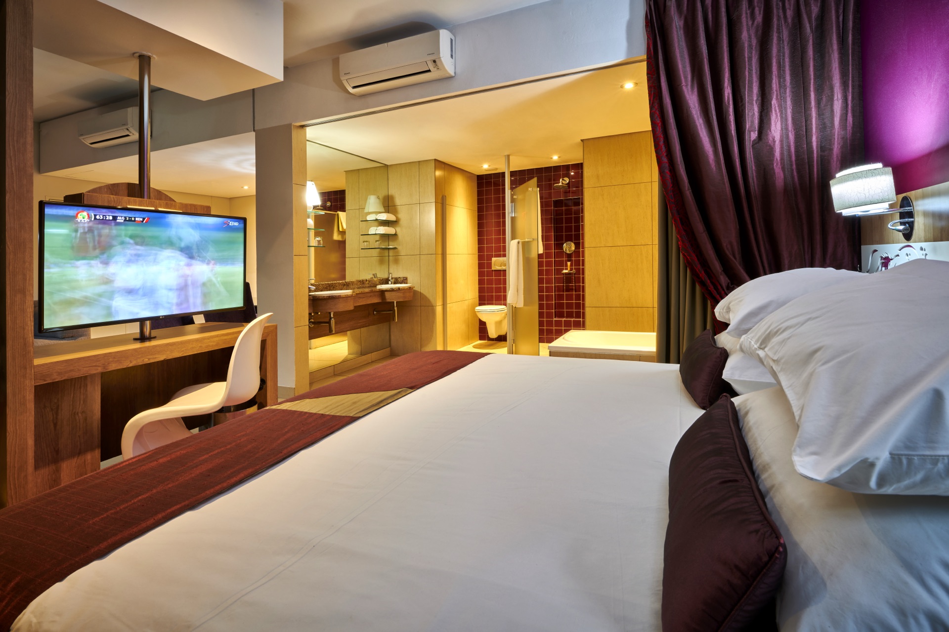 Executive Suite bedroom with open ensuite bathroom and tub at Rio, Klerksdorp