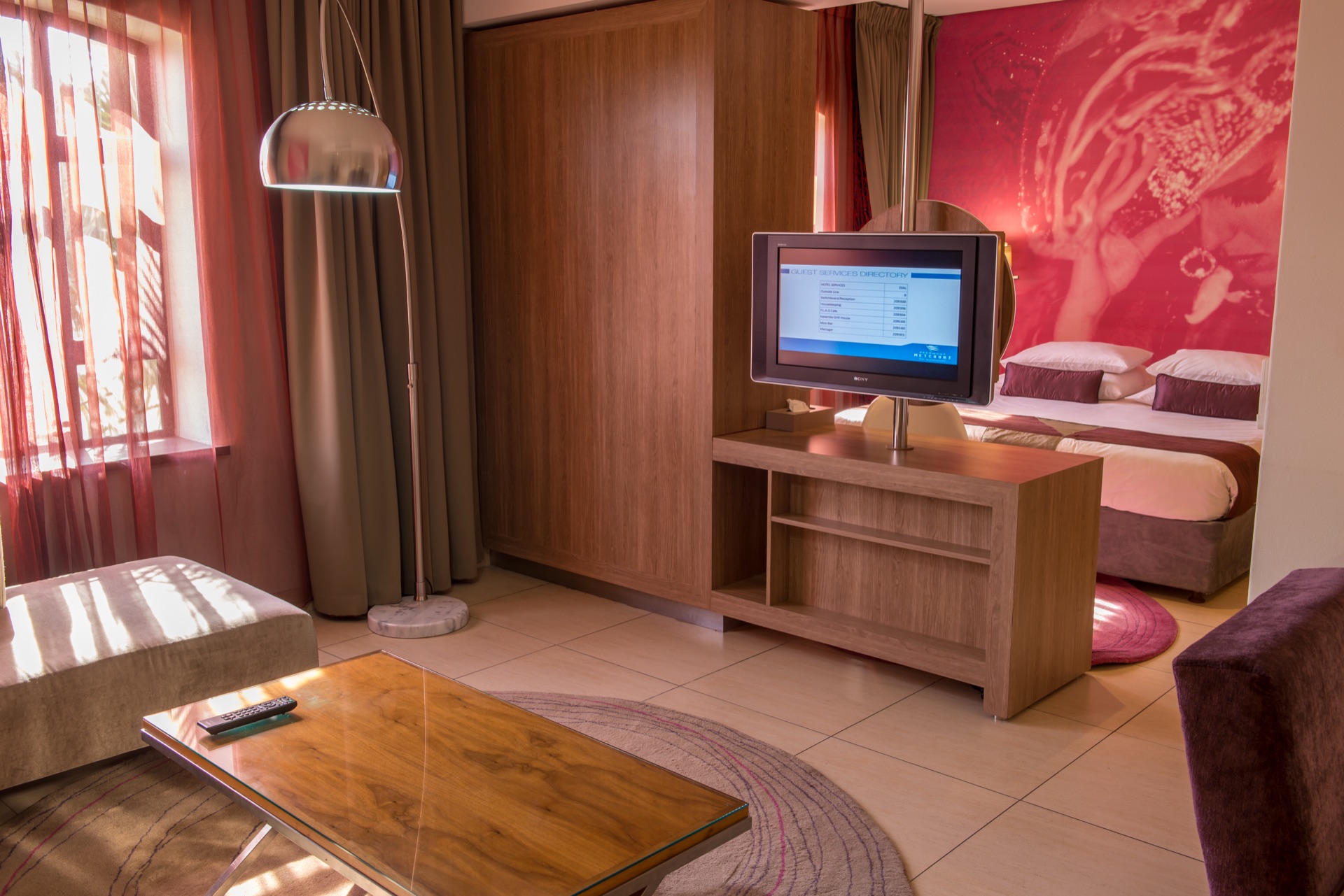 Executive Suite lounge with sofa and swivel TV facing the bedroom at Rio, Klerksdorp
