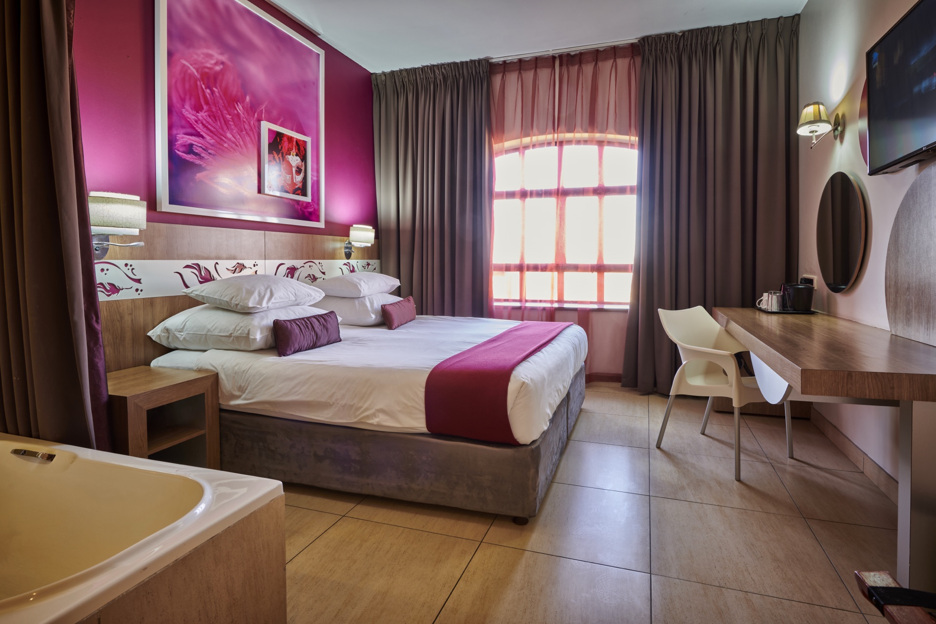 Superior King room with king bed, desk, tub and arched window at Rio, Klerksdorp