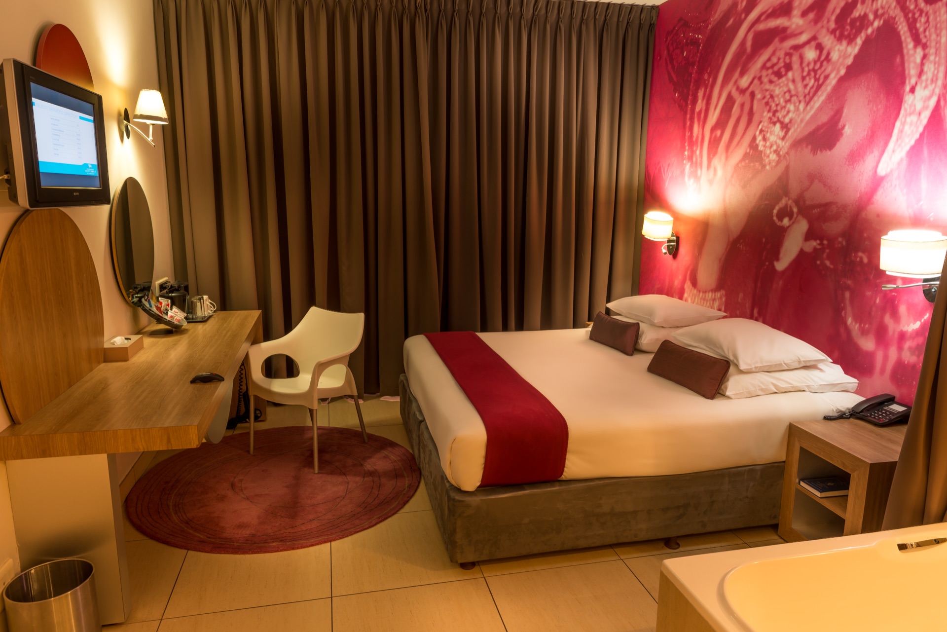 Superior King room with king bed, writing desk and wall-mounted TV at Rio, Klerksdorp
